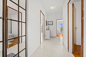 A hallway with a tiled floor, a white refrigerator, and a door leading to another room. - Petra Sea View Apartment 4 (Kampor)