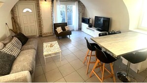 Ein gemütliches Wohnzimmer mit einer Couch, einem Couchtisch und einem Fernseher.