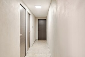 A narrow hallway with two doors, one of which is open, and a closed door at the end. - Refugio Moderno - Steps from the U.S. Embassy and Polanco (Ciudad de México)