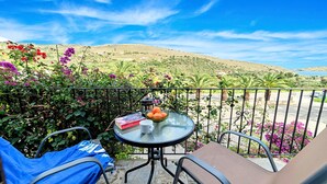 A balcony with a table, chairs, and a view of a hilly landscape. - Welcome Apts laid just 1600m away from the longest sandy beach of northern Crete and the touristic Georgioupolis Town, offering great views to the Cretan Sea and the White Mountains.  Welcome Apts is ideal for couples, families, a group of families or a g (Exopoli)
