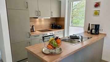 A modern kitchen with a wooden countertop, stainless steel sink, and a built-in oven.