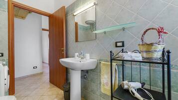 A bathroom with a sink, mirror, and towel rack.
