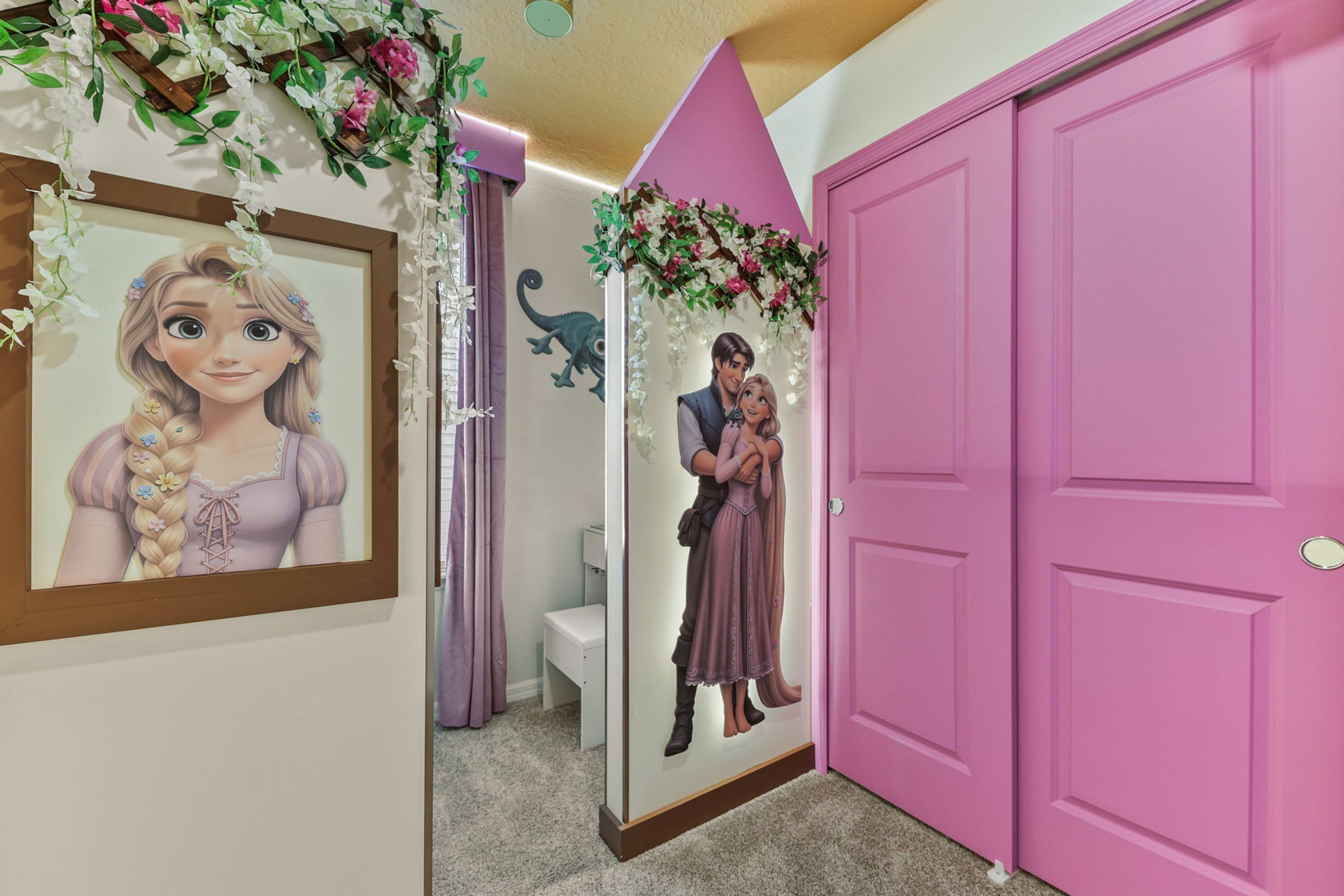Un pasillo con una puerta rosa, un cuadro enmarcado y un arco decorativo.