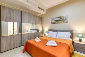 A hotel room with a large bed, a wardrobe with mirrors, a painting on the wall, and two bedside lamps. - Marsaskala Escape | Pool, Beaches & Local Charm (Marsaskala)