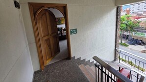 A staircase leading to a wooden door with a sign indicating 'Escalera.' - Casa Hotel Realeza del Estádio (Medellín)