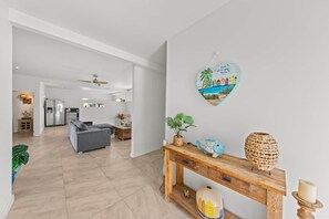 A modern living room with a grey sofa, a wooden console table, and a heart-shaped wall decoration. - Damberde House, Damascus Resort, Jan Thiel (Jan Thiel)