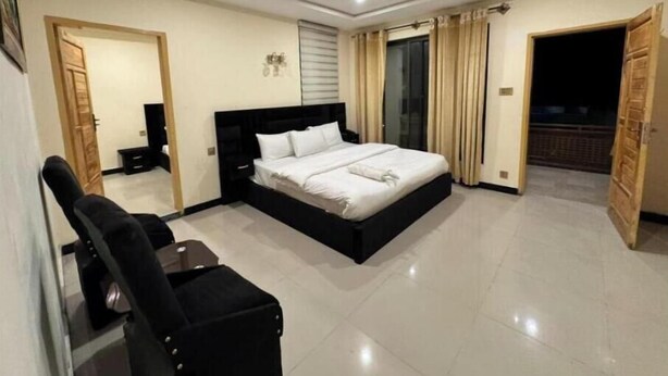 A bedroom with a bed, a desk, a chair, a TV, and a balcony. - Elegant Mountain Escape – Superior King Room in Kachura (Ponedas)