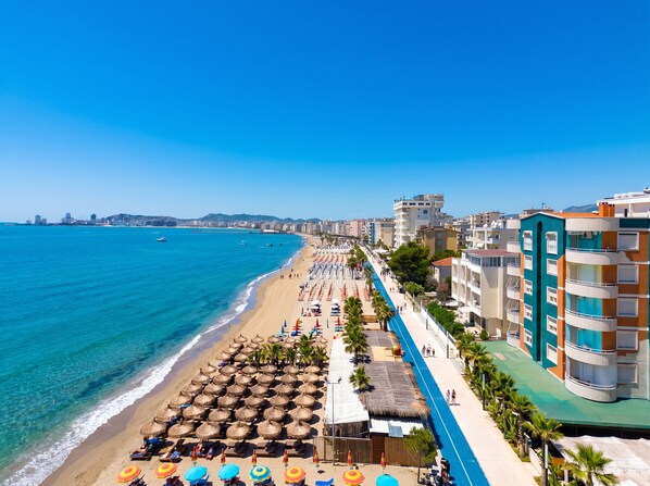 A beachside hotel with a long promenade, beach umbrellas, and a view of the sea. - Cozy Apartment 70 meters from Durres Beach (Durres)