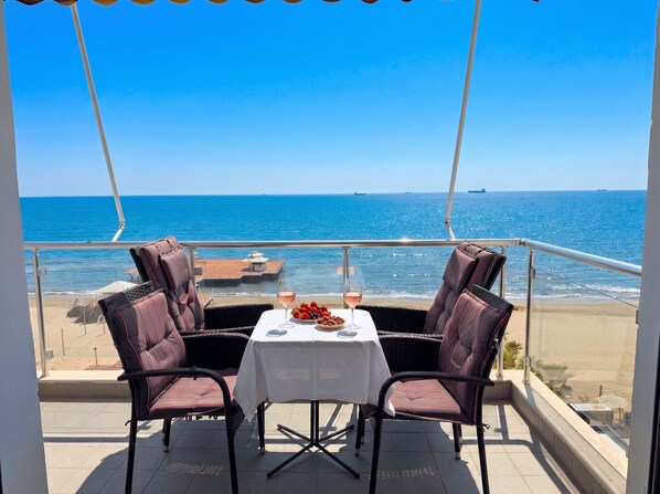 A balcony with two chairs and a table, overlooking the sea. - Beachfront- Sea View Holiday Home 105 (Durres)
