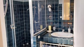 A bathroom with a glass shower enclosure, a sink with a mirror, and a tiled floor. - Nature lovers Close to the BEAUVAL zoo and the Loire castles (CHATILLON SUR INDRE)