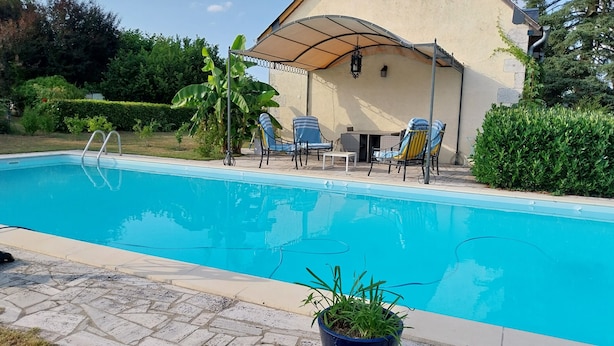 A swimming pool with lounge chairs, a covered patio, and a potted plant. - Nature lovers Close to the BEAUVAL zoo and the Loire castles (CHATILLON SUR INDRE)