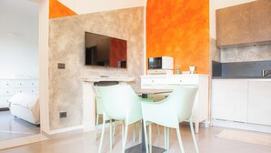 A modern kitchen with a flat-screen TV, a microwave, and a dining area with two chairs. - Quiet and Central: Discover Pisa on Foot (Pisa)