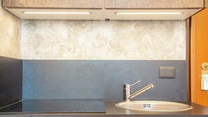A modern kitchen with a stainless steel sink, a faucet, and a light switch on the wall. - Quiet and Central: Discover Pisa on Foot (Pisa)