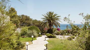 A pathway leading to a building with a view of the sea.