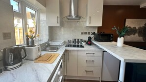 Una cocina moderna con horno empotrado, microondas y cafetera.