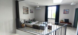 Un apartamento moderno con balcón, un sofá, una mesa de comedor y obras de arte en las paredes.