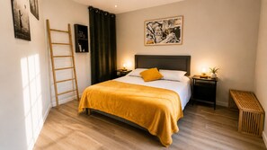 Un dormitorio con cama, mesita de noche, escaleras, un marco de foto y una cortina.