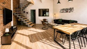 Ein zeitgemäßer Wohnraum mit Treppe, Essbereich und Sitzecke.