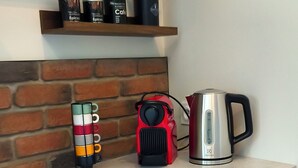 Eine Küchenarbeitsplatte mit Wasserkocher, Tassenhalter und Kaffeemaschine.