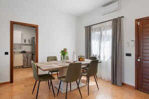 A dining area with a table, chairs, and a vase of flowers. - Vacation Villa 'Andrada' with Private Pool, Wi-Fi and Air Conditioning (Yaiza)