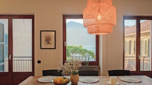 A dining table with a vase of flowers, a bowl of fruit, and a candle. - Authentic house with beautiful view of lake como (Musso)