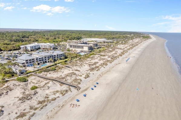 A coastal hotel with multiple buildings, a sandy beach, and a clear view of the ocean. - Tranquil Coastal Escape - Studio-steps Driftwood (Jekyll Island)