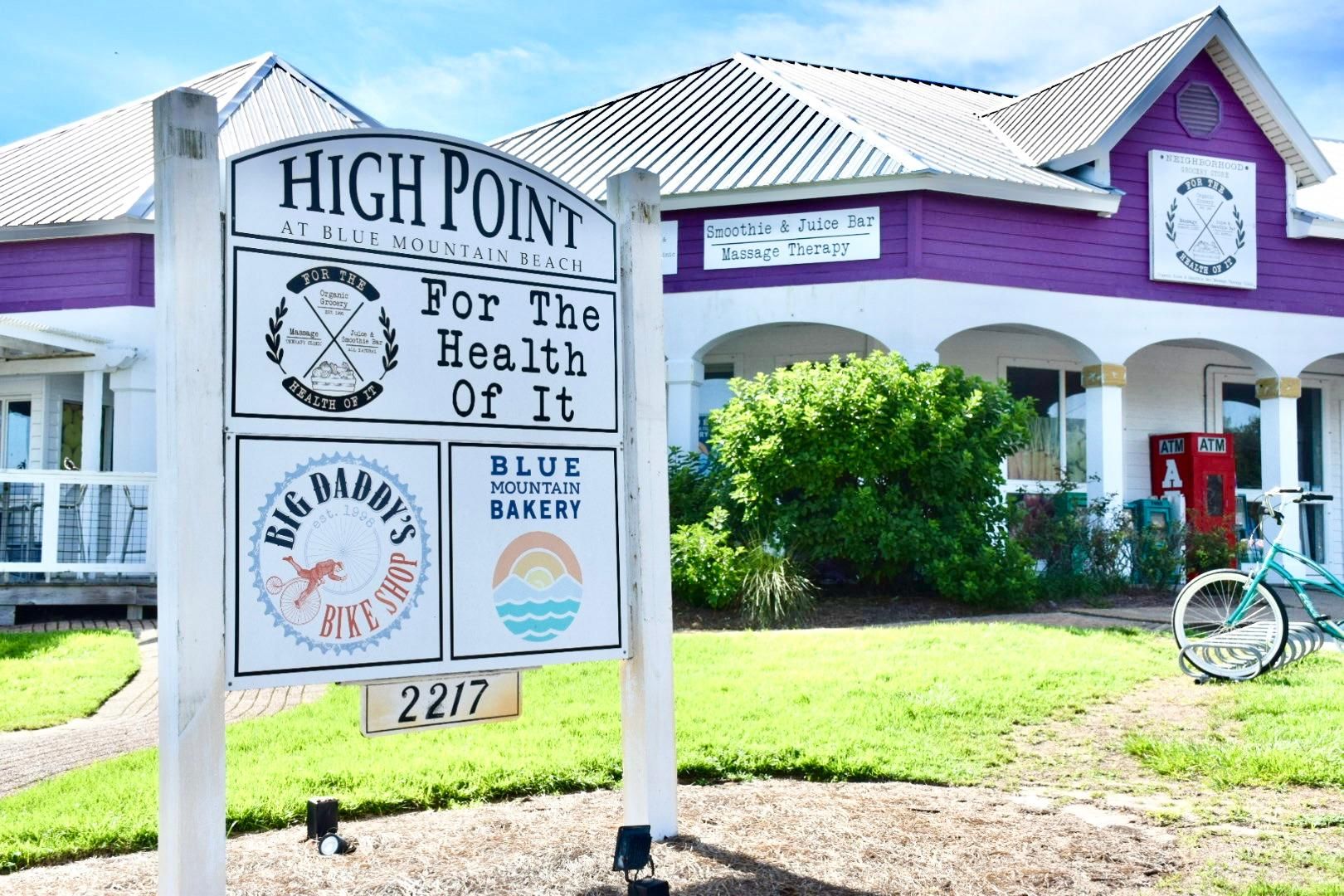 A sign for High Point At Blue Mountain Beach with logos for Big Daddy's Bike Shop and Blue Mountain Bakery.