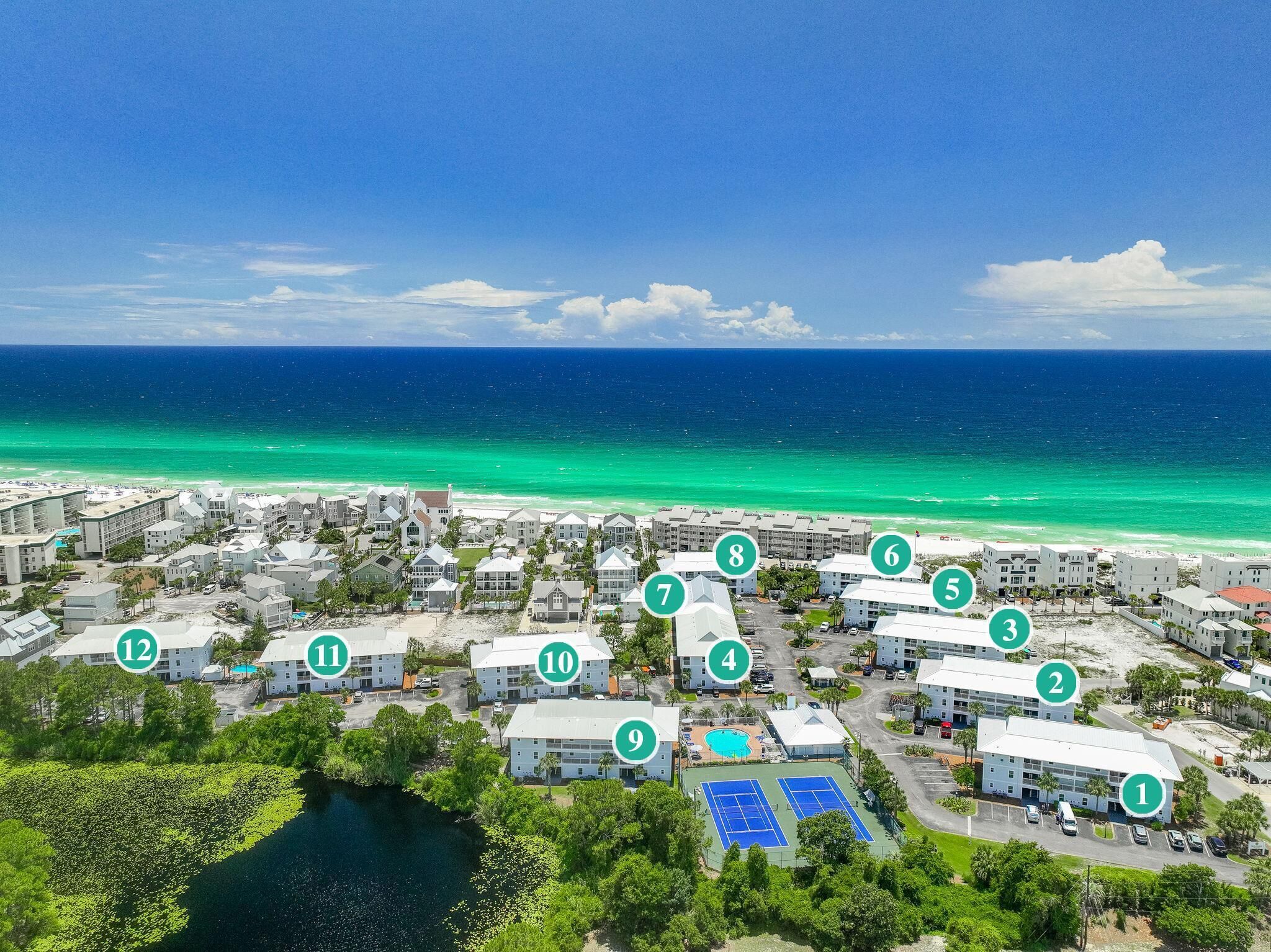 A coastal resort with numbered buildings, a beach, and a tennis court.