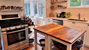 A modern kitchen with an oven, stove, and wooden table. - Downtown Mill Valley Vintage Spanish Villa with Beautiful Garden (Mill Valley)