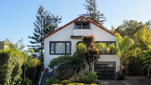 A two-story house with a white exterior, a red roof, and a garage. - Downtown Mill Valley Vintage Spanish Villa with Beautiful Garden (Mill Valley)