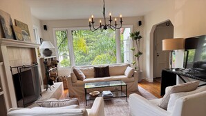 A living room with a fireplace, sofa, coffee table, and TV. - Downtown Mill Valley Vintage Spanish Villa with Beautiful Garden (Mill Valley)