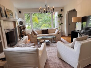 A living room with a fireplace, sofa, coffee table, and TV. - Downtown Mill Valley Vintage Spanish Villa with Beautiful Garden (Mill Valley)