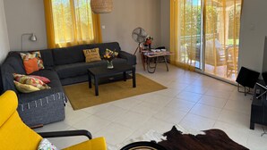 Una sala de estar con sofá, mesa de centro y ventilador.