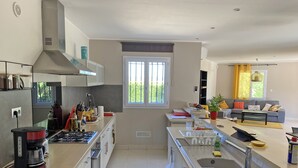 Una cocina moderna con estufa a gas, horno y un amplio ventanal.
