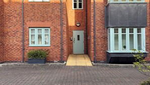 A brick house with a front door, two windows, and a small garden. - St Johns Courtyard Suite, Bridgnorth with free private parking (Bridgnorth)