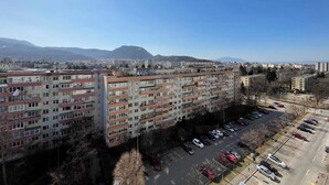 A multi-story residential building with a parking lot in front. - Stunning Panoramic View Last Floor Save (Brasov)