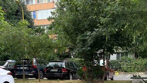 A parking lot with cars, a yellow bollard, and a manhole cover. - Stunning Panoramic View Last Floor Save (Brasov)