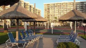 A hotel with a pool area featuring lounge chairs and thatched umbrellas. - Beachfront Saida condo with Gulf views, resort pools, room for 6 and a $75 beach gear rental credit. (South Padre Island)