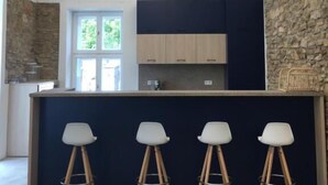 A kitchen with a stone accent wall, a bar area with stools, and a skylight.