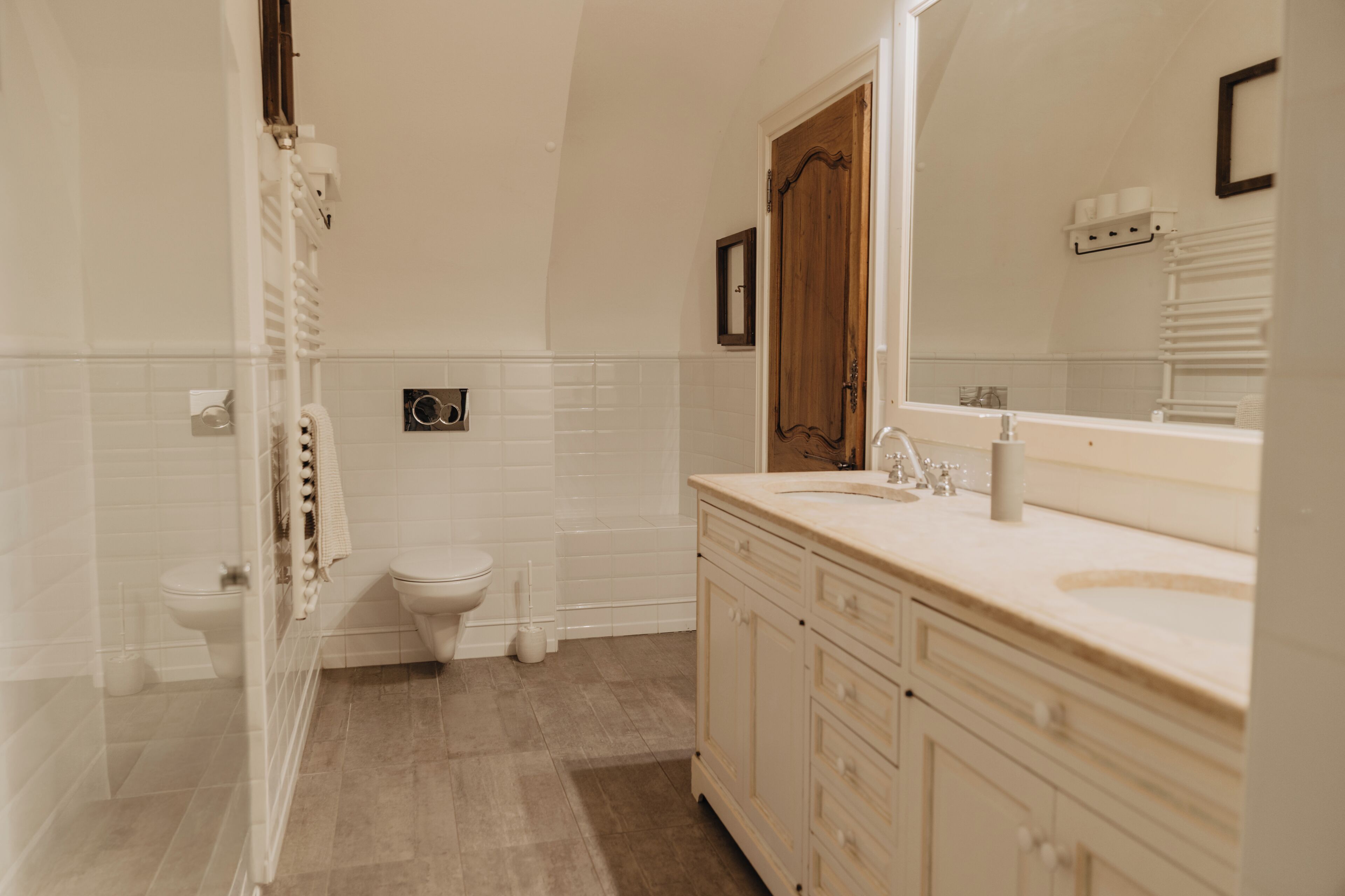 A bathroom with a toilet, bidet, and a sink with a mirror.