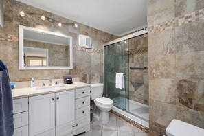 A modern bathroom with a glass-enclosed shower, a large mirror, and a white sink. - Beachfront Sea Vista condo with wraparound Gulf-view balcony + $75 beach gear rental credit (South Padre Island)