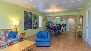 Ein Wohnzimmer mit einer Couch, einem Sessel und einem Essbereich mit Stühlen und einem Tisch.