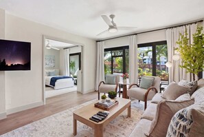 A modern living room with a sofa, armchairs, a coffee table, and a TV. - B-115 - Totally Updated - First Floor- Sleeps 6 (Naples)