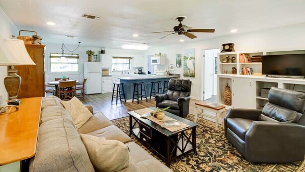 A modern living room with a sofa, coffee table, and a TV. - River`s Edge Retreat (McComb)