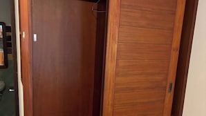 Un armadio in legno con ante scorrevoli, una maniglia in metallo e un pavimento piastrellato.