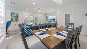 Een moderne eetruimte met een houten tafel, grijze stoelen en blauwe placemats.