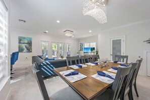 Un comedor moderno con una mesa de madera, sillas grises y caminos de mesa azules.