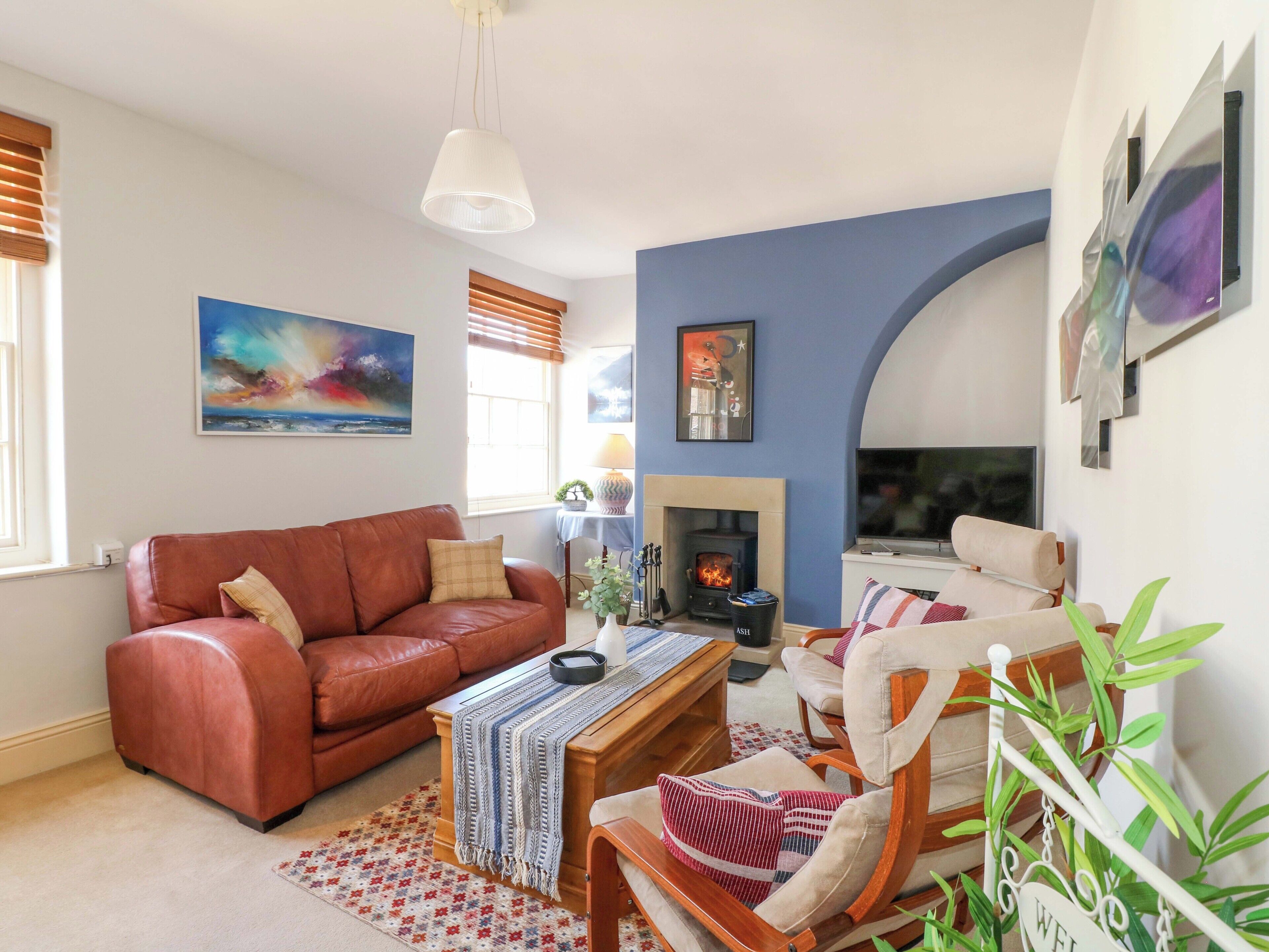 A living room with a fireplace, a sofa, a coffee table, and a TV.