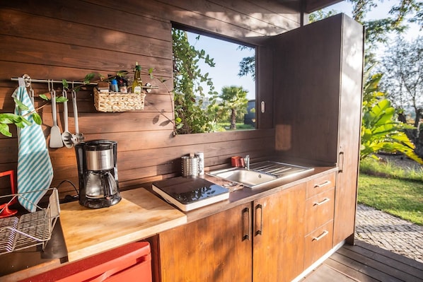 A modern kitchen with wooden cabinetry, a coffee maker, a sink, and a window overlooking greenery. - 'silves' Cabin-cato Preto-adults-only Guesthouse (Silves)