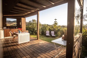 A wooden deck with a bar area, a table, and two chairs. - 'silves' Cabin-cato Preto-adults-only Guesthouse (Silves)